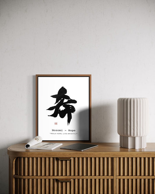 Framed artwork with black calligraphy on a wooden sideboard against a light gray wall.