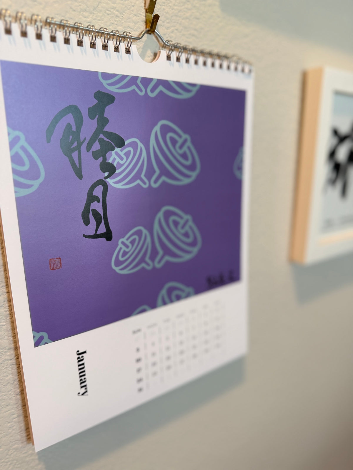 2027 calligraphy wall calendar hanging on a wall, open to January 睦月