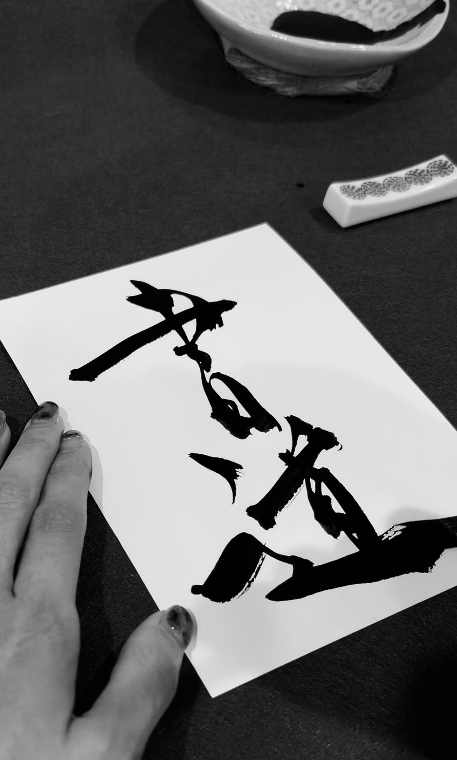 Japanese calligraphy artist Assaa holding fresh sumi ink brushwork on washi paper — BrushForma studio