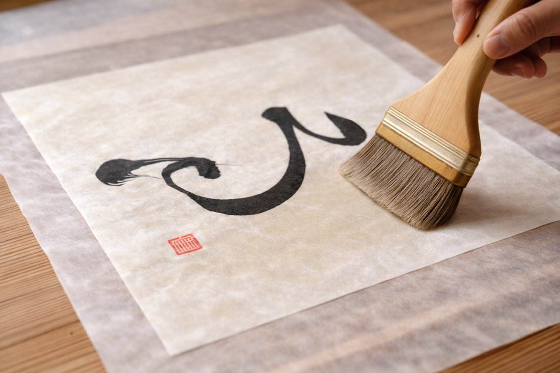 Hand using brush to create Japanese calligraphy on rice paper, minimalist wall art