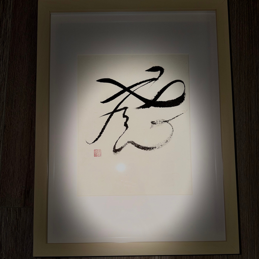 Framed Japanese calligraphy wall art with bold black brushstrokes on white paper