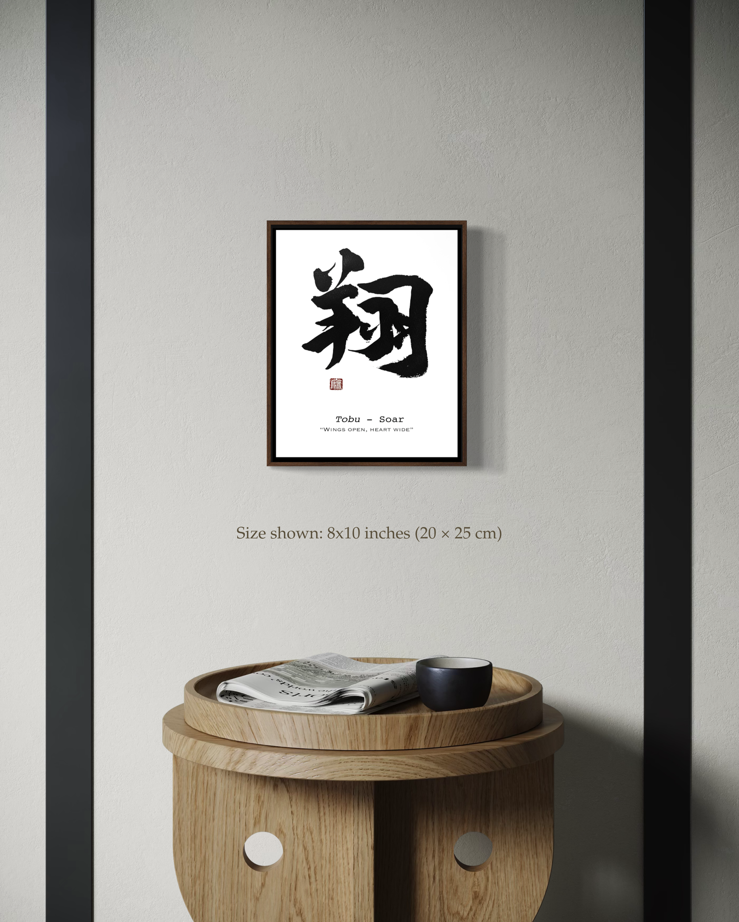 Framed calligraphy artwork on a wall above a wooden side table.