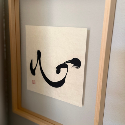 Framed minimalist Japanese calligraphy art print with bold black brushstroke on white paper