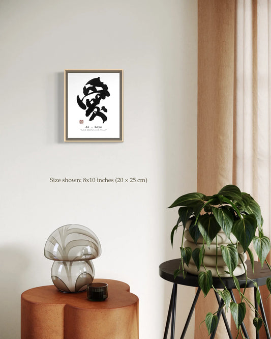 Framed Japanese calligraphy wall art print displayed in a minimalist, modern interior with neutral decor, table lamp, and potted plant.