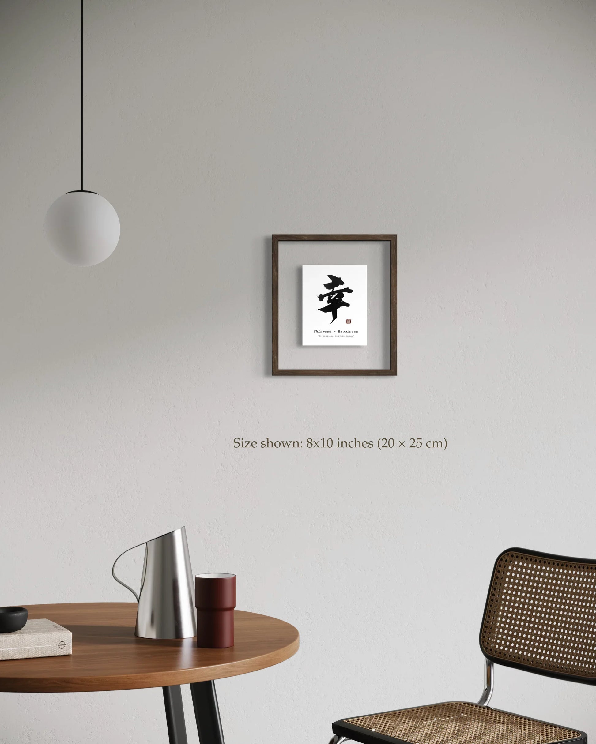 Framed artwork on a wall above a table with a chair in a minimalistic room.