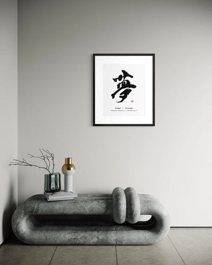 Framed japanese calligraphy artwork with a black and white design on a gray wall above a modern concrete bench.