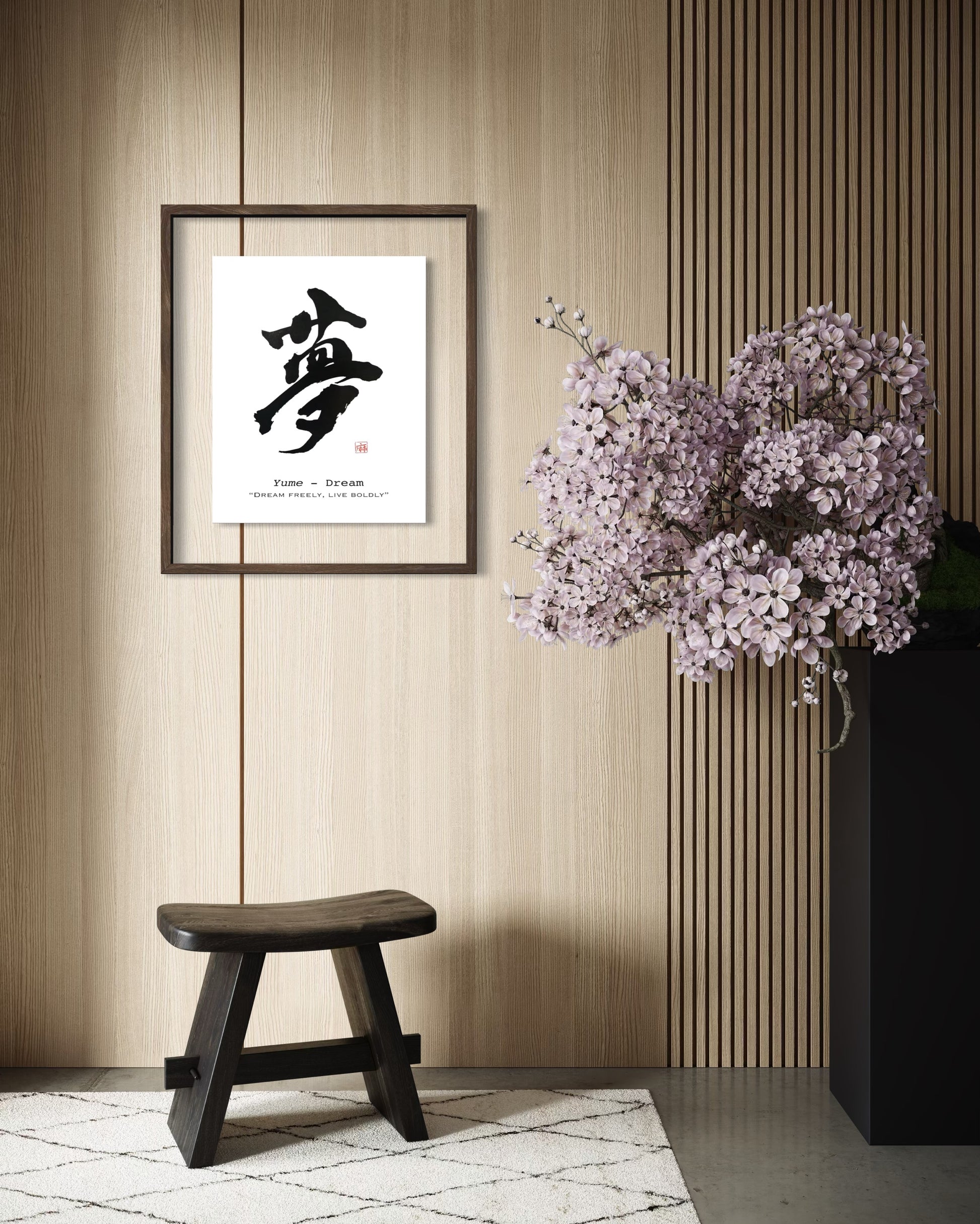 Framed japanese calligraphy artwork on a wall with a wooden stool and floral arrangement.