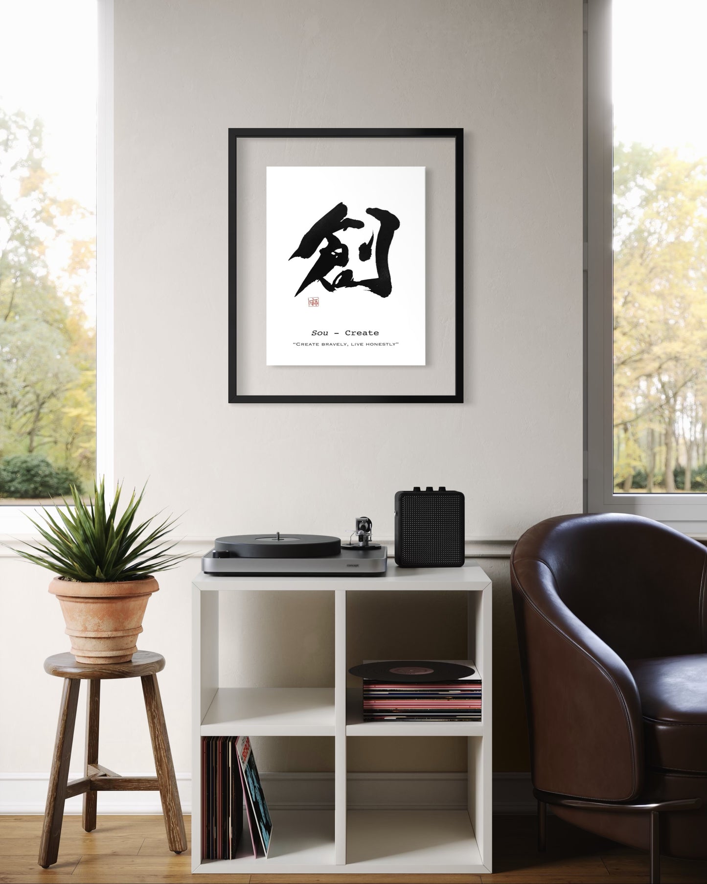Framed japanese calligraphy artwork  on a wall in a room with a shelf, chair, and plant.