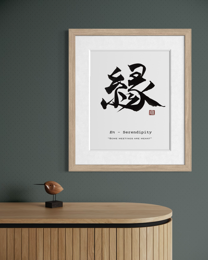 Framed artwork with calligraphy and text on a wall above a wooden cabinet.