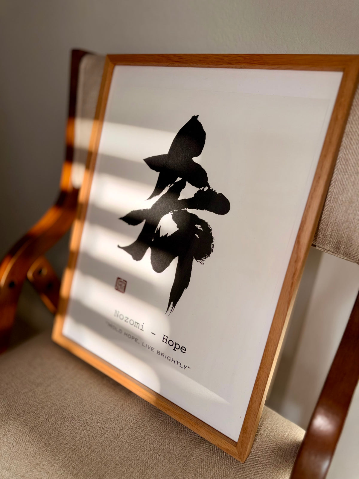 希 Nozomi (Hope) calligraphy print in a wooden frame, leaning in soft sunlight