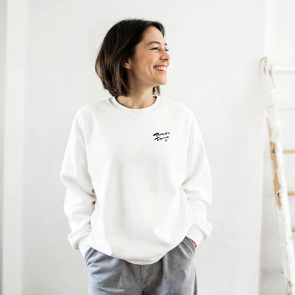 Woman wearing the white NIPPON sweatshirt with the BrushForma brush logo on the chest