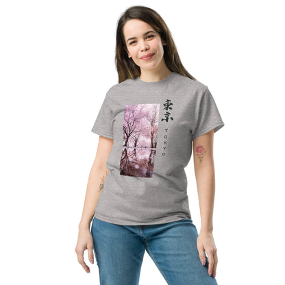Woman wearing a grey unisex T-shirt with pink cherry blossom Tokyo art print and calligraphy.